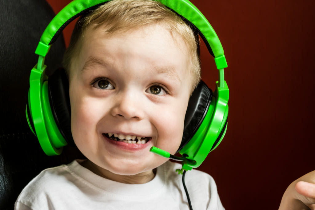 toddler boy waring bright green headphones and smiling