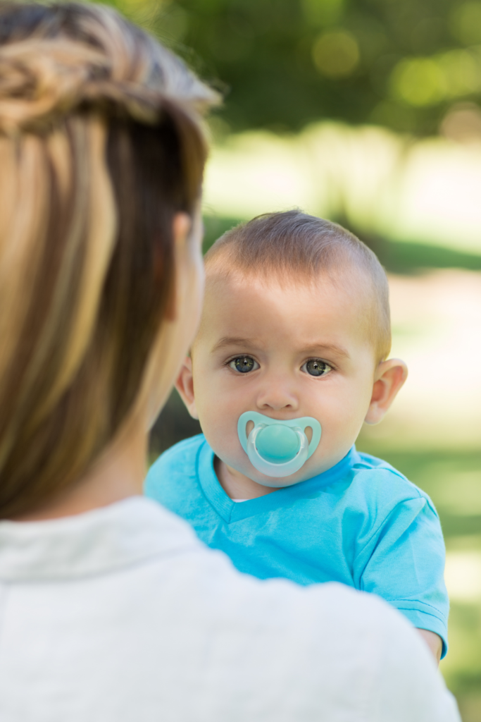 best pacifiers for breastfed babies, baby in blue shirt with blue pacifier in mouth, baby pacifier, pacifier
