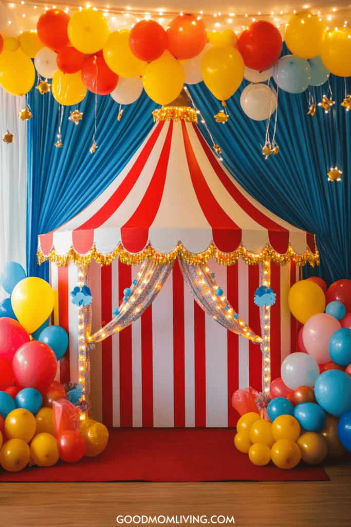 Colorful circus-themed party backdrop featuring a striped tent adorned with fairy lights, surrounded by vibrant balloons in various colors, creating a festive atmosphere for celebrations.
