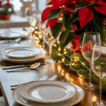 A festive dining table set for a holiday meal with elegant white dishware trimmed in gold, surrounded by silverware and wine glasses. The table is decorated with red poinsettias and illuminated by warm string lights, creating a cozy atmosphere.