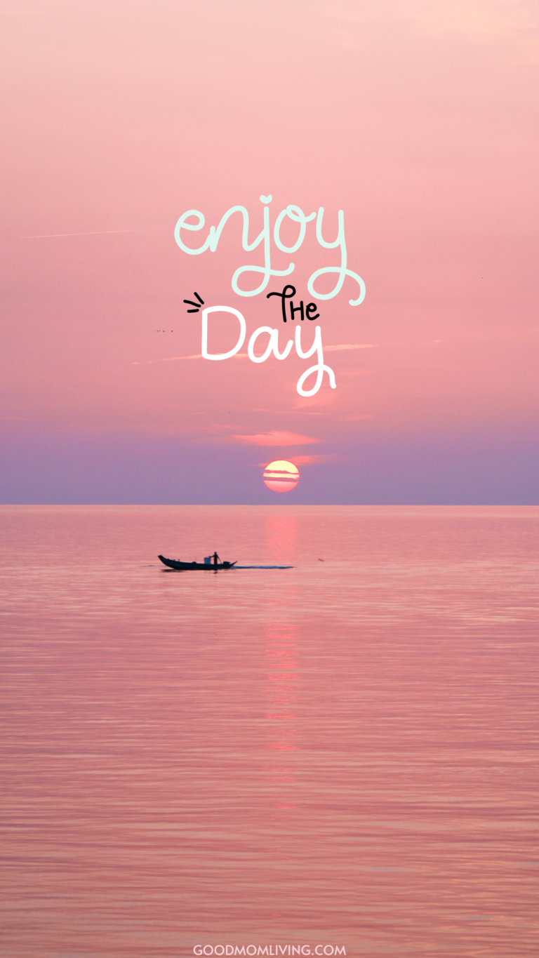 A serene ocean sunset with a pastel pink sky, featuring a silhouette of a small boat on the calm water and the phrase 'enjoy the day' written in playful white letters.