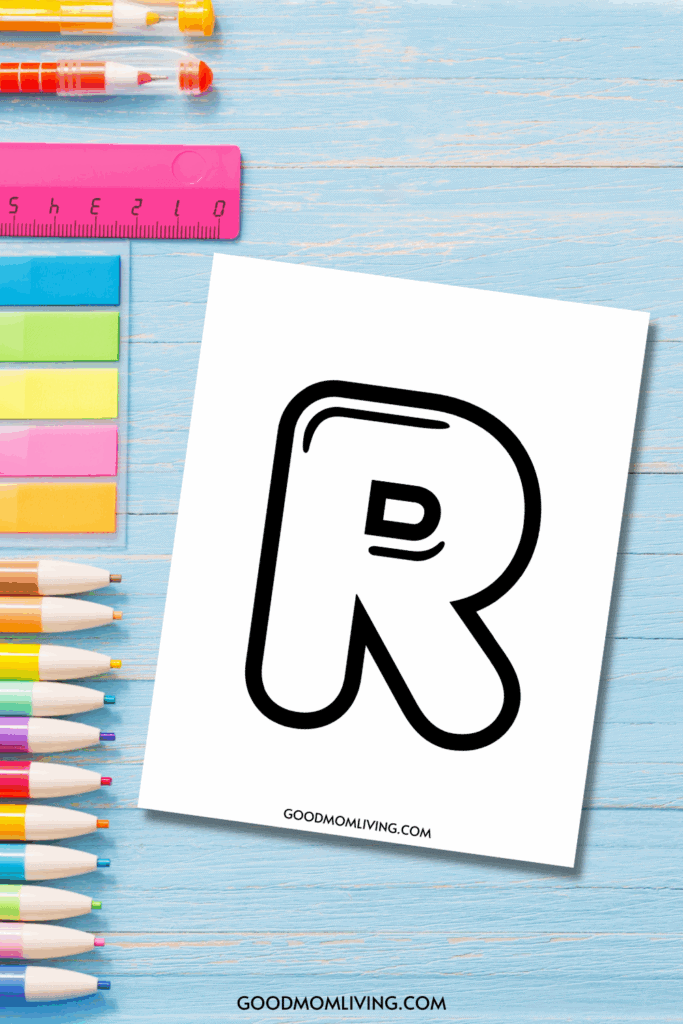 A stylized black letter 'R' on a white sheet of paper, surrounded by colorful pens, note papers, and a pink ruler on a blue wooden surface.